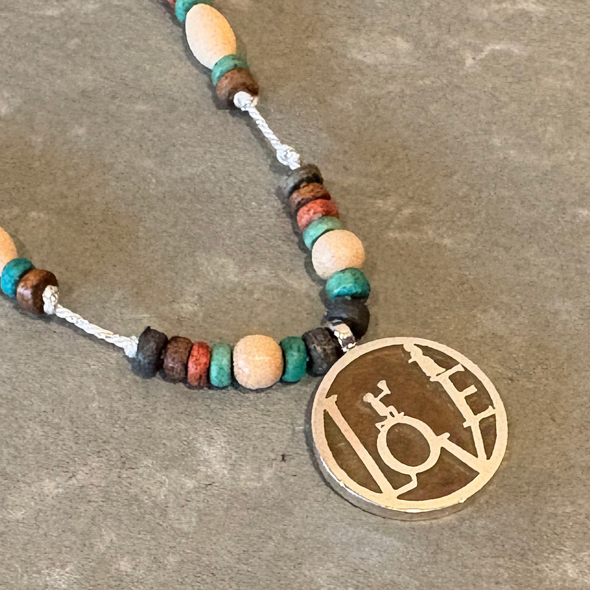 物語の一場面・花束を持ち告白するシルエットのビーズペンダント「CONFESSION COIN PENDANT 2」9