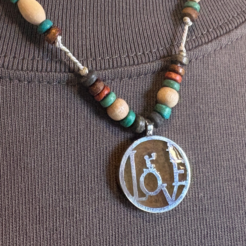 物語の一場面・花束を持ち告白するシルエットのビーズペンダント「CONFESSION COIN PENDANT 2」1