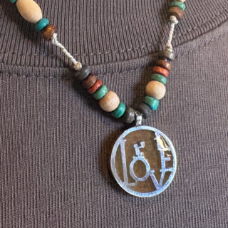 物語の一場面・花束を持ち告白するシルエットのビーズペンダント「CONFESSION COIN PENDANT 2」1